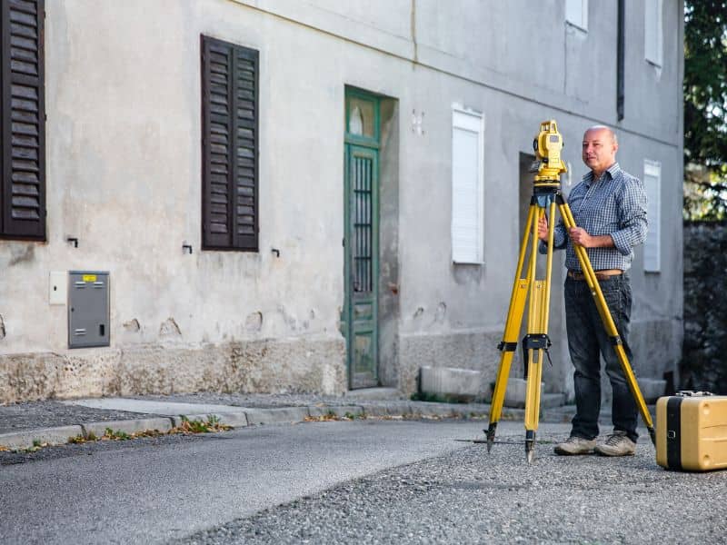 Land surveyor measuring a residential access lane in San Antonio Texas
